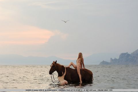 Голая тоненькая лесби Dariya A с соседкой обнаженными скачут на коне по берегу